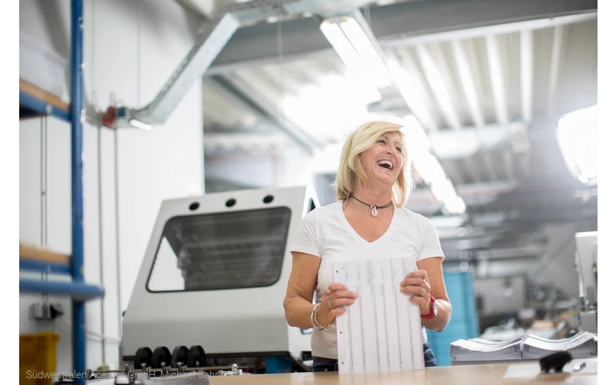 Mitarbeiterin an einem Druckerei-Arbeitsplatz