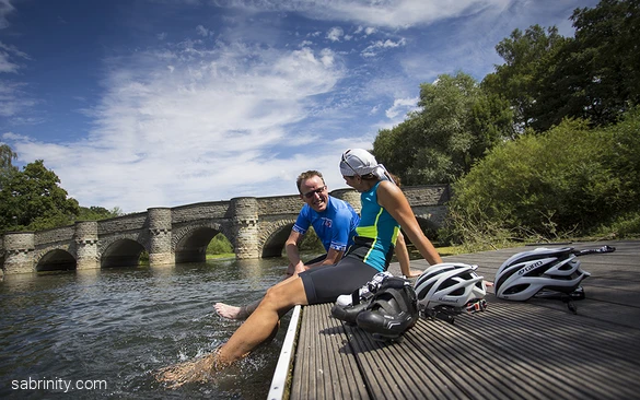 Radfahrende kühlen ihre Füße im Wasser ab