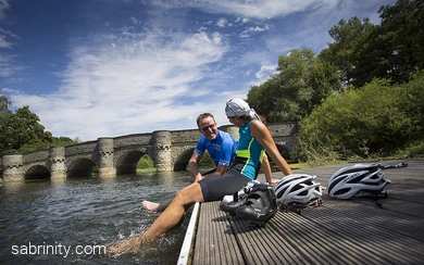Radfahrende kühlen ihre Füße im Wasser ab
