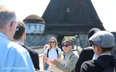 Gruppe im Rahmen einer Gästeführung auf der Staumauer mit Fokus auf die Gästeführerin