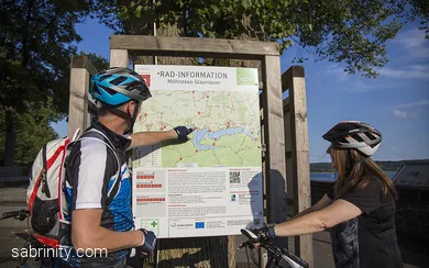 Radfahrende vor Knotenpunktkarte am Möhnesee