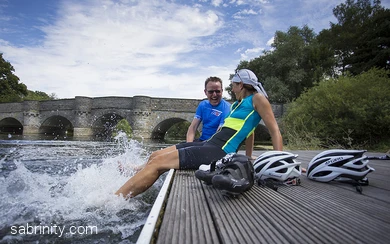 Radfahrende plantschen mit Füßen im Wasser