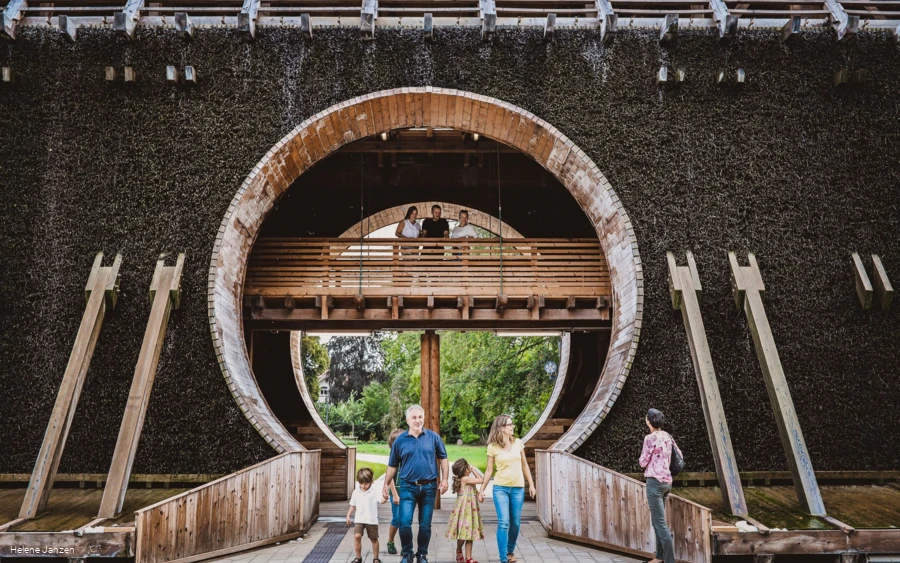 Familie geht durch das Gradierwerk aus Holz und Stein in Bad Sassendorf.