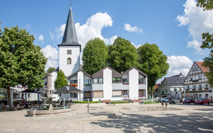 Pankratiusplatz mit Brunnen, Kirchturm und umliegenden Gebäuden