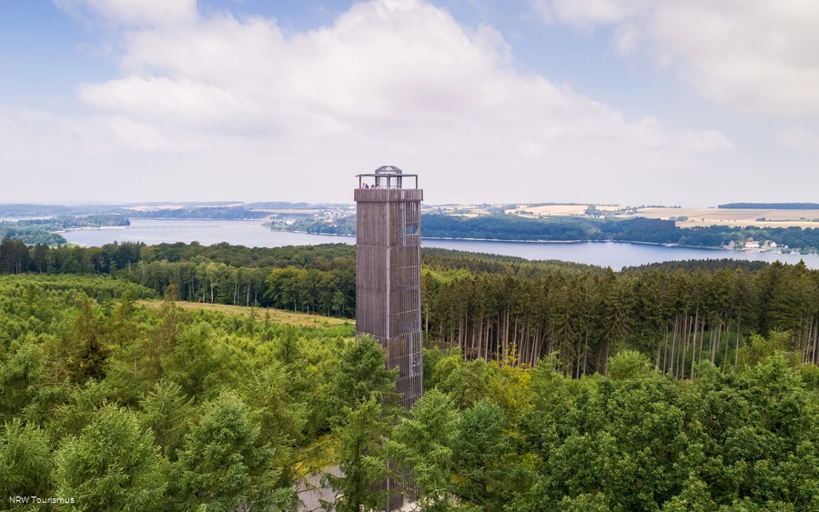 Luftaufnahme des Möhneseeturms inmitten eines weitläufigen Waldgebiets mit Blick auf den Möhnesee