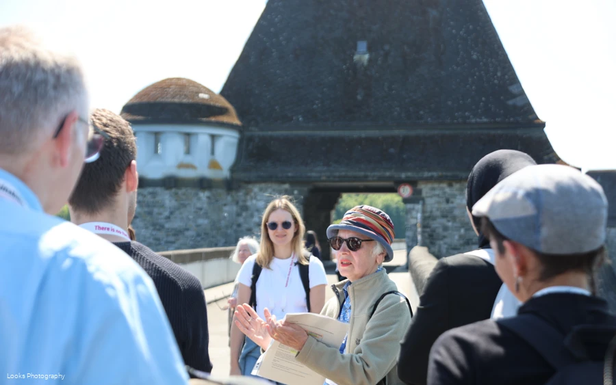 Gruppe im Rahmen einer Gästeführung auf der Staumauer mit Fokus auf die Gästeführerin