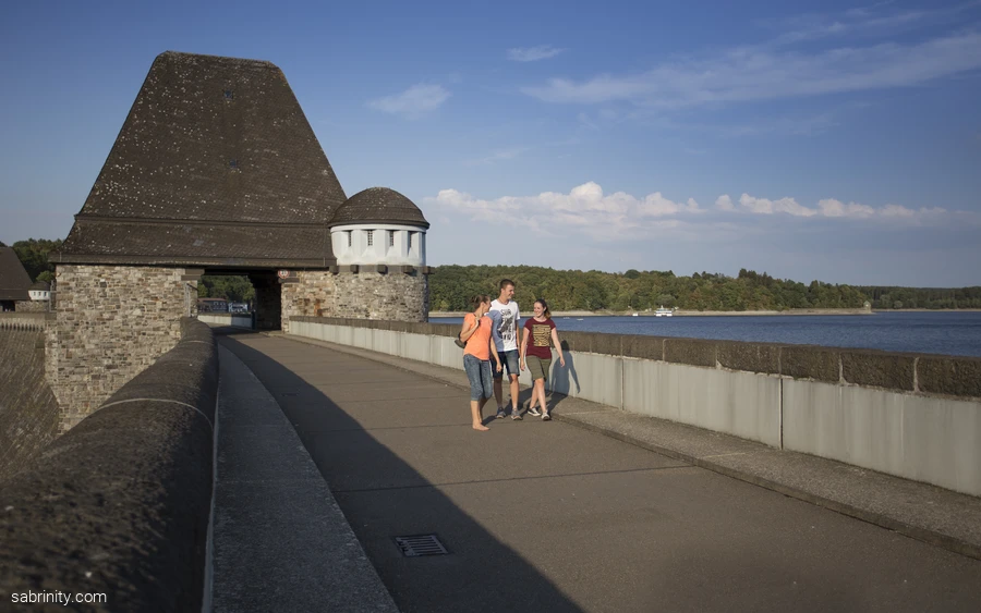 Junge Erwachsene wandern über die Staumauer