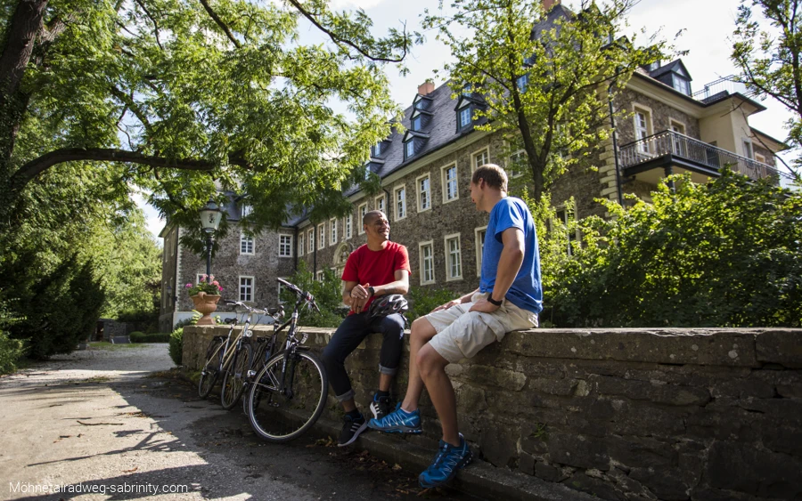 Radfahrer pausierend vor Unterkunft