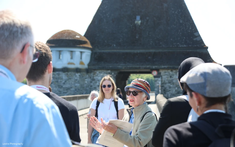 Person spricht vor einer Gruppe auf der Staumauer des Möhnesees.