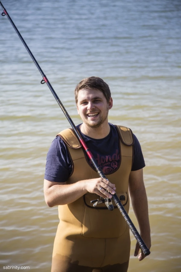 Person in Wathose h&auml;lt eine Angelrute und steht im Wasser des M&ouml;hnesees.