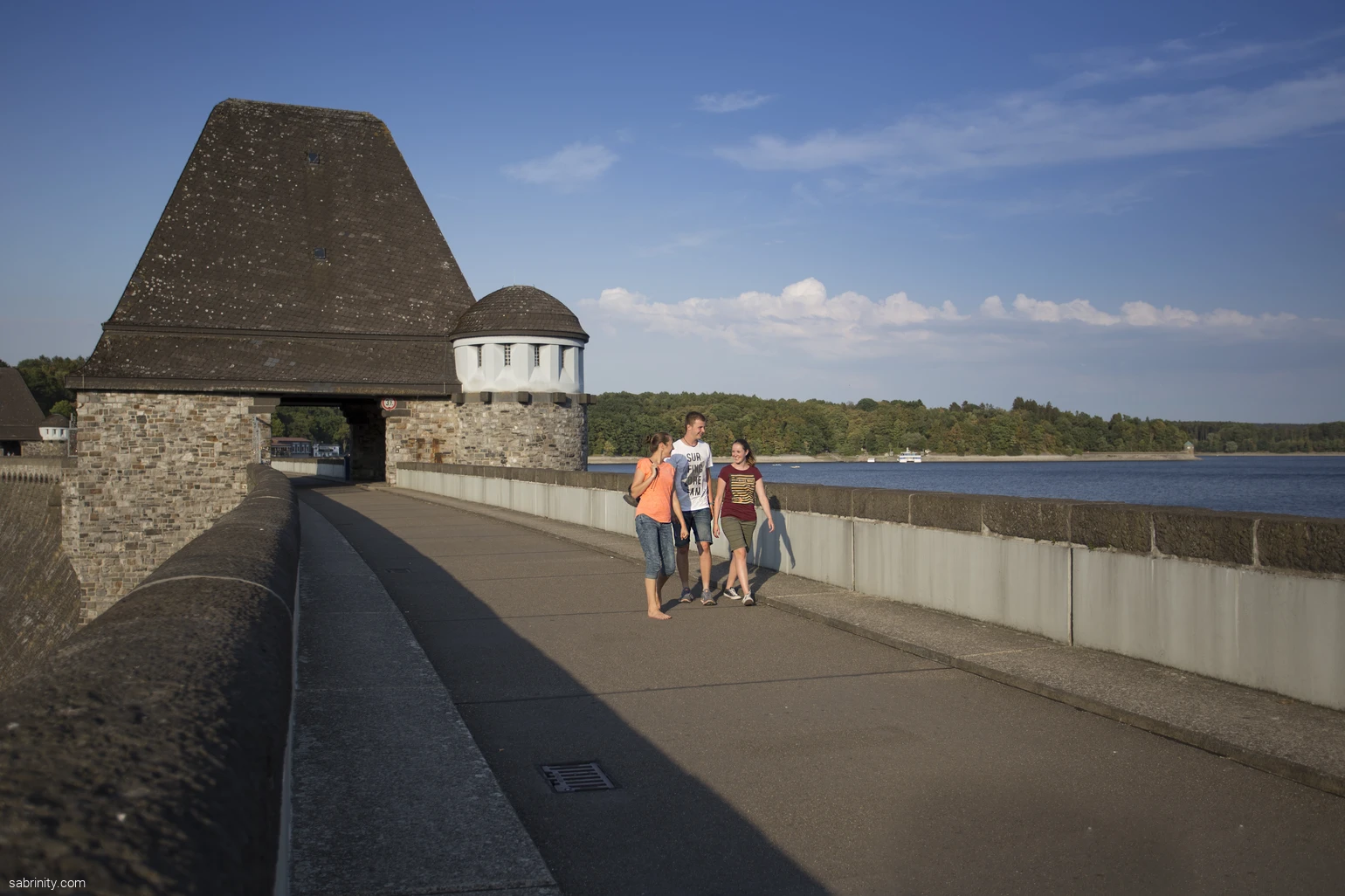 Junge Erwachsene wandern über die Staumauer